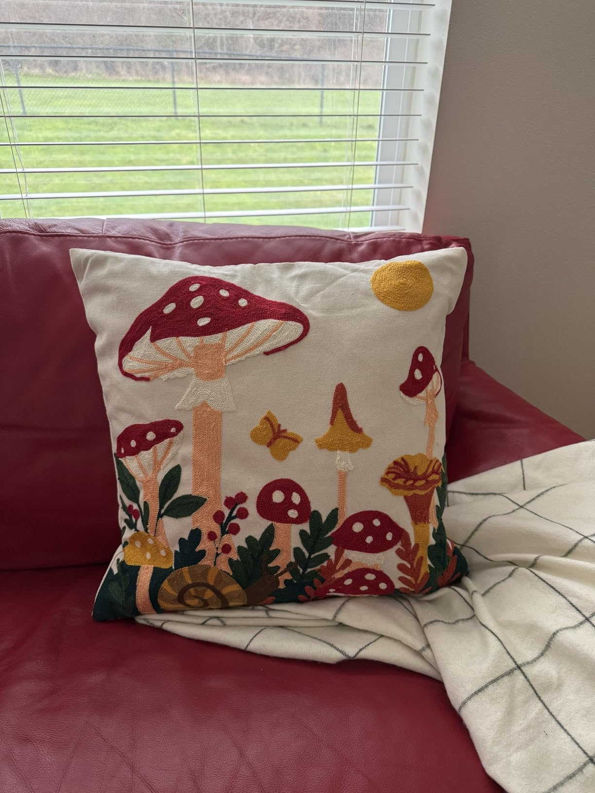 Mushroom Moon pillow cover on a red sofa