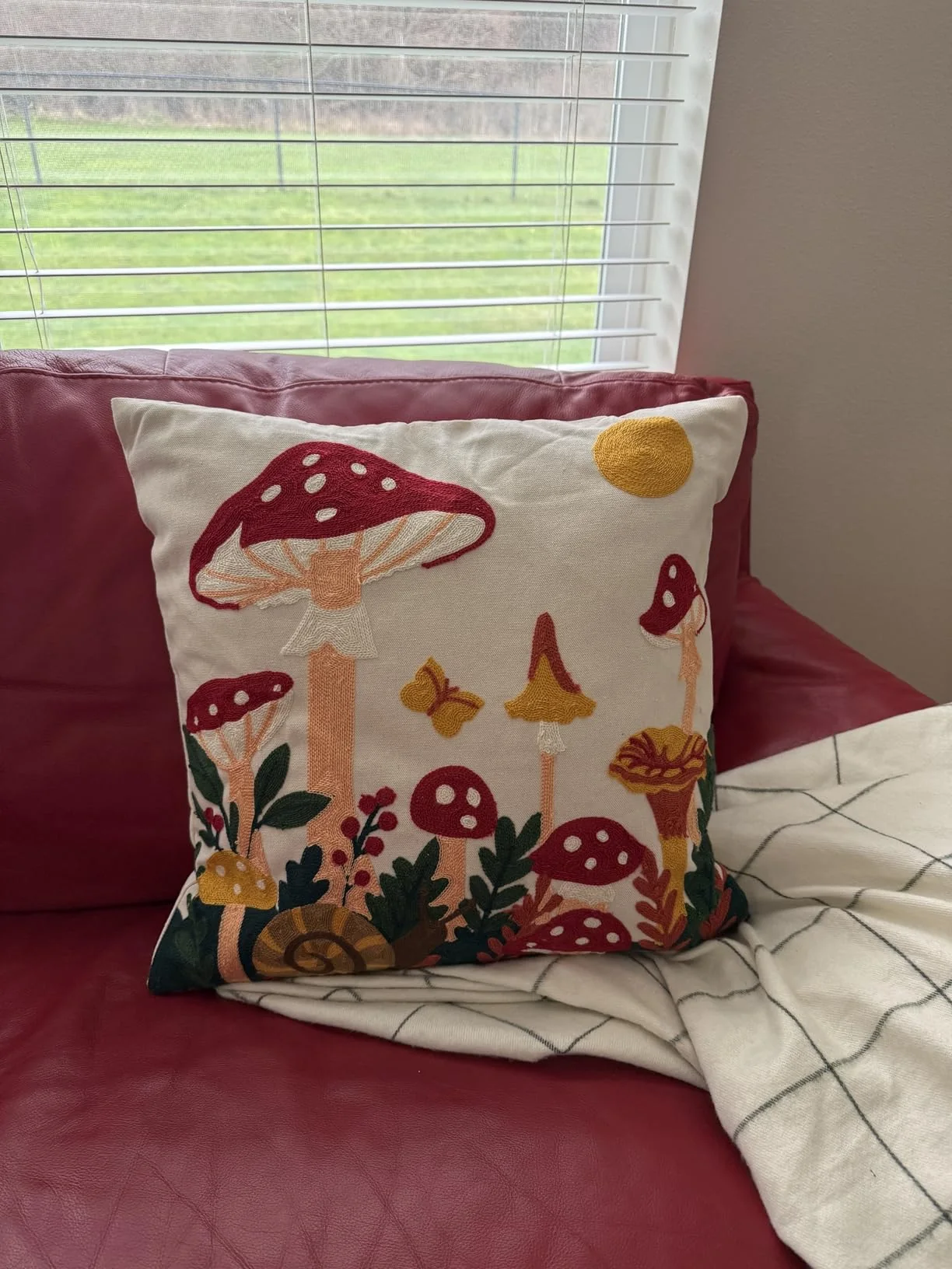 Mushroom Moon pillow cover on a red sofa